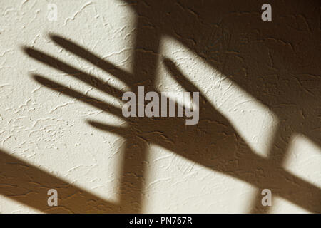 Shadow of a hand on white wall Stock Photo