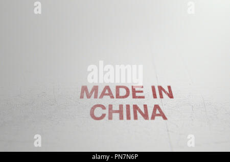 An extreme close up of a worn print sign that reads made in china on a flat white plastic product surface - 3D render Stock Photo