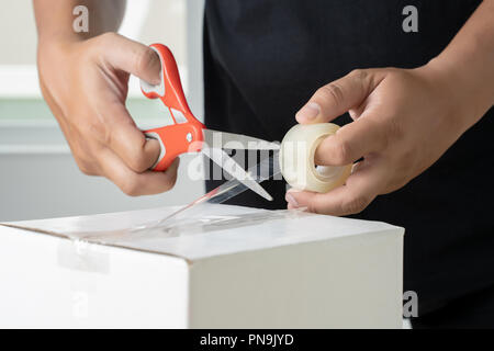 man hand transparent  man packing box adhesive tape. Stock Photo