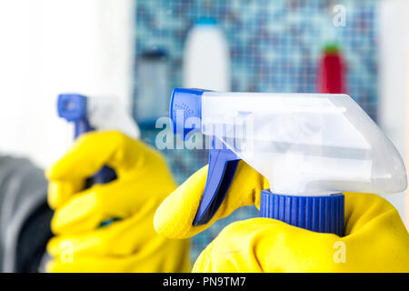 Person doing chores in bathroom at home cleaning mirror with spray detergent Stock Photo