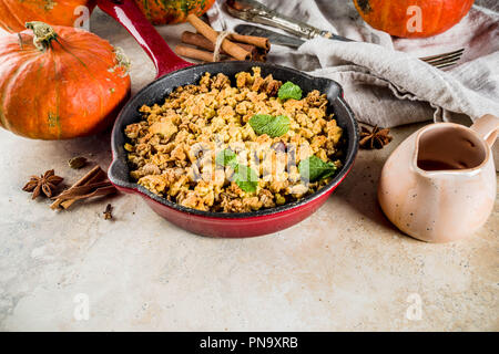 Homemade autumn pastries, pumpkin crumble pie in a cast-iron frying pan, light stone background, copy space top view Stock Photo