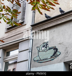Berlin, Prenzlauer Berg. Urban street scene. Apartment building, two pigeons, diseased chestnut tree and street art paste-up by Dared Stock Photo