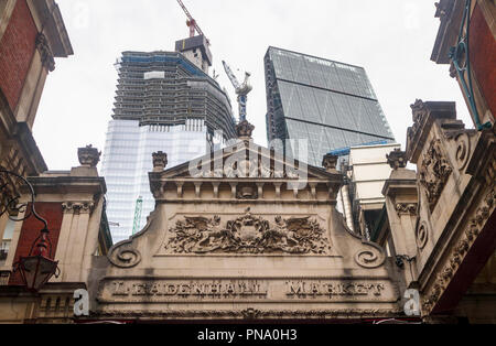 Entrance of historic Leadenhall Market with iconic Cheesegrater skyscraper and 22 Bishopsgate partially glazed under construction, City of London EC3 Stock Photo