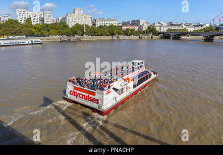 City Cruises cruise boat on the River Thames by Festival Pier and Waterloo Bridge, London, Shell-Mex House and Cleopatra's Needle on the Embankment