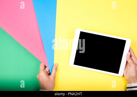 Woman hand holding colorful paper samples and tablet computer Stock Photo