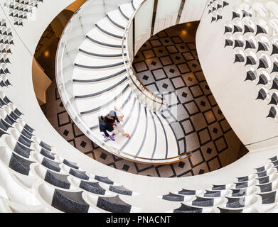 View from above of woman walking down spiral staircase at the Tate Modern in London Stock Photo