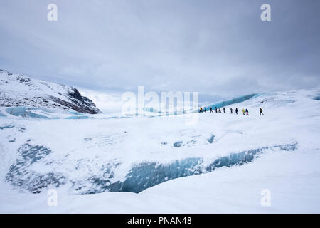 Tourists wearing protective clothing for glacier hike on Svinafellsjokull glacier an outlet glacier of Vatnajokull, South Iceland Stock Photo