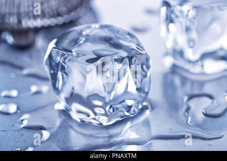 Two ice cubes melting on a steel bar top. Stock Photo