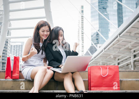 Two businesswomen online shopping laptop computer with successful emotion. Business entrepreneur using internet and making homepage for sell digital p Stock Photo