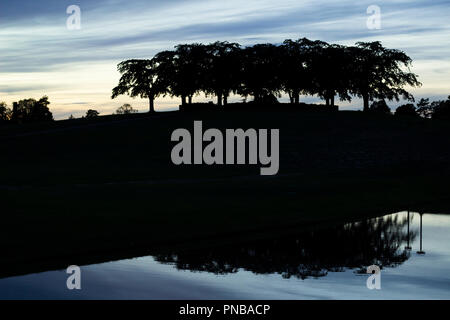 Stockholm, Sweden - September 13 2018: The meditaion grove Almhöjden reflected in a pond, at the Woodland Cemetery (world heritage) at twilight. Symme Stock Photo