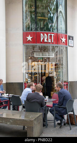 men conversing at outdoor table, Prêt a Manger store, City of London, England, UK Stock Photo
