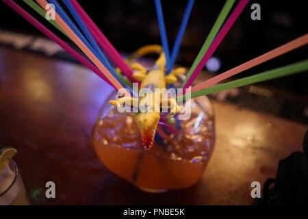 A 'lethal' alcoholic drink serviced in a fish bowl with plastic alligator toy Stock Photo