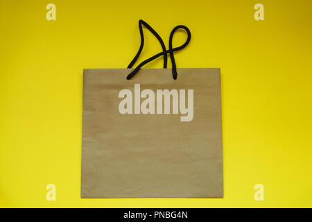 shopping paper bag top view on yellow background with copy spacepackage. Stock Photo