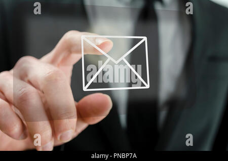Businessman touching email icon on a virtual screen. Stock Photo