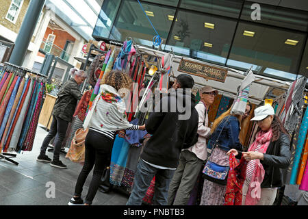 People shopping for scarves at a scarf stall 'Kashimi Scarves' in Spitalfields Market near Brick Lane in East London E1 UK  KATHY DEWITT Stock Photo