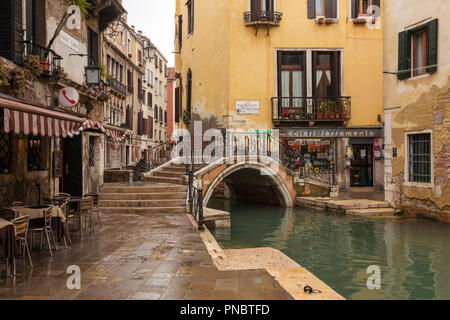 Venice, Italy - March 19, 2018: Old bridge over the narrow venetian canal among old  houses in Venice, Italy. Stock Photo