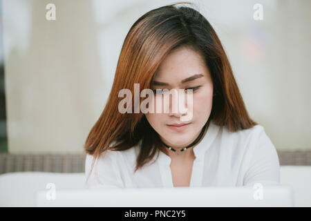 asian women professional work hard looking down at laptop screen in working office. Stock Photo