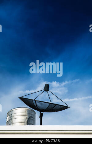 Satellite dish on roof top, TV communication technology connect people from around the world. Stock Photo