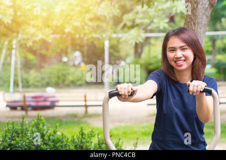 young asian smile enjoy chest exercise in the park for healthy, women workout outdoor. Stock Photo