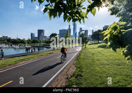 Bicycle riders on Lakefront Trail with the Chicago, IL skyline. Stock Photo