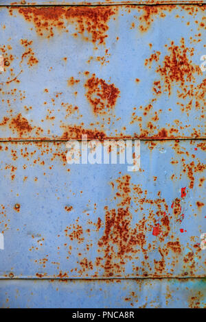 Background. The texture of the old rusty metal plate with cracks and three horseshoe and rivets Stock Photo
