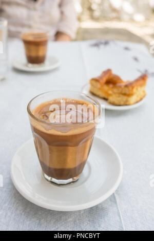 Traditional greek coffee served with a piece of pie in outdoor cafe in Greece Stock Photo