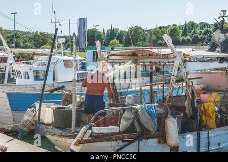 Fisherman preparing an old fishing boat to go to sea. The quota for catching fish. Small business Stock Photo