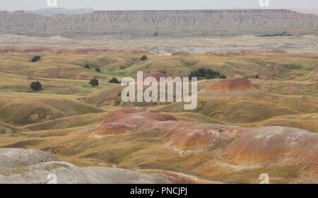 gently rolling hills with yellow prairie grasses and reddish colored sediments Stock Photo