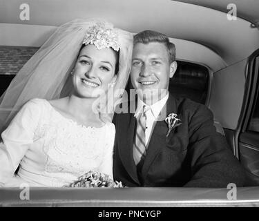 1960s SMILING HAPPY JUST MARRIED BRIDE AND GROOM SITTING IN BACK SEAT OF LIMOUSINE TOGETHER LOOKING AT CAMERA  - b22782 HAR001 HARS FUTURE NOSTALGIA OLD FASHION AUTO SEAT STYLE VEHICLE PLEASED JOY LIFESTYLE CELEBRATION FEMALES MARRIED SPOUSE HUSBANDS LUXURY HALF-LENGTH LADIES PERSONS AUTOMOBILE MALES JUST CONFIDENCE TRANSPORTATION B&W EYE CONTACT DREAMS HAPPINESS HEAD AND SHOULDERS CHEERFUL FORMAL DRESS ADVENTURE AND AUTOS EXCITEMENT IN OF SMILES CONNECTION AUTOMOBILES JOYFUL STYLISH VEHICLES MORNING DRESS MID-ADULT MID-ADULT MAN TOGETHERNESS WIVES YOUNG ADULT WOMAN BLACK AND WHITE Stock Photo