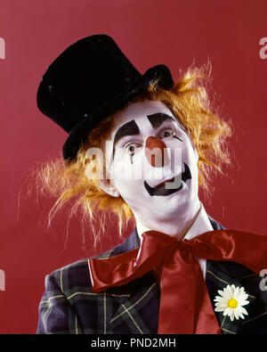 1970s SILLY WHITE FACE RED NOSE CLOWN LOOKING AT CAMERA WEARING TOP HAT ORANGE HAIR WIG PLAID JACKET AND RED RIBBON NECK TIE  - kc5322 PHT001 HARS CONFIDENCE ORANGE EXPRESSIONS EYE CONTACT BIZARRE SUCCESS PERFORMING ARTS HAPPINESS WEIRD PERFORMER AND EXCITEMENT ZANY UNCONVENTIONAL OF ENTERTAINER OCCUPATIONS WHITEFACE COULROPHOBIA ACTORS NECK TIE STYLISH IDIOSYNCRATIC AMUSING ECCENTRIC ENTERTAINERS MID-ADULT MID-ADULT MAN PERFORMERS TOP HAT YOUNG ADULT MAN CAUCASIAN ETHNICITY ERRATIC OLD FASHIONED RED NOSE Stock Photo