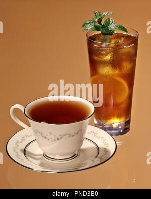 1970s TEA Camellia sinensis HOT TEA PLAIN IN CHINA CUP AND SAUCER COLD TEA IN TALL GLASS WITH ICE LEMON SLICE AND MINT GARNISH  - kf38899 FRT001 HARS AROMATIC CONCEPTUAL STILL LIFE CLOSE-UP PLAIN STYLISH FORMS SYMBOLIC BREWED ICED TEA MINT REFRESHING REFRESHMENT RELAXATION DAILY OLD FASHIONED REPRESENTATION SAUCER Stock Photo