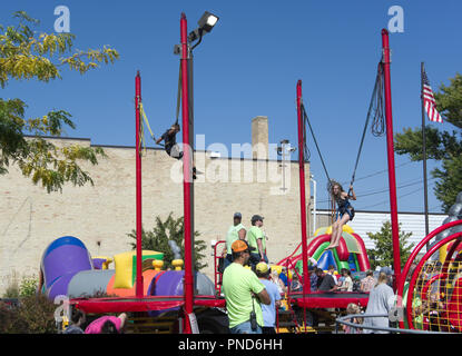 Two children playing on Rebound Unlimited Trampoline at street fair, Two Rivers, Wisconsin Stock Photo