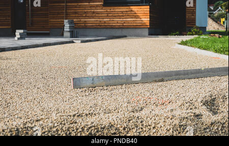 Laying gray concrete paving slabs in house courtyard driveway patio. Professional workers bricklayers are installing new tiles or slabs for driveway,  Stock Photo