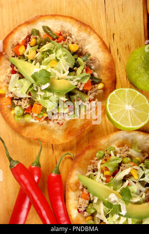 Crunchy beef tostada stack, typical mexican food, made with crispy fried corn tortillas with guacamole, cheese, sour cream and salsa Stock Photo