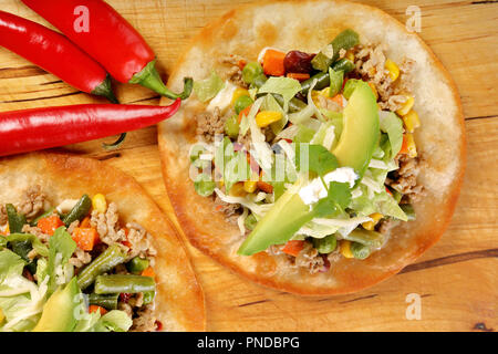 Crunchy beef tostada stack, typical mexican food, made with crispy fried corn tortillas with guacamole, cheese, sour cream and salsa Stock Photo