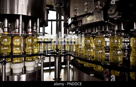 Sunflower oil in the bottle moving on production line. Shallow dof. Stock Photo