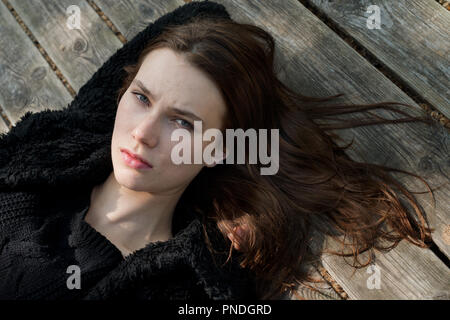 Beautiful young  woman lying on wooden floor Stock Photo