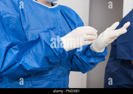 Nurse putting on surgical gloves Stock Photo