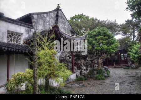 Decorative roofs, gazebo, small pond with rocks around, trees and flowes these are traditional architectonical elements of chinese gardens. Stock Photo