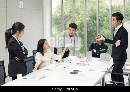 Business negotiation, male partners arguing, funny easygoing woman keeping calm in stressing situation, meditating with composed smile, dealing with e Stock Photo