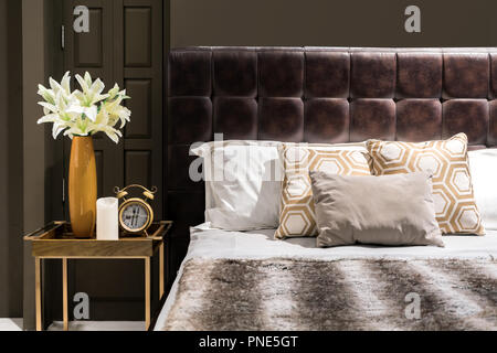 Luxury bedroom with brown color tone and flower vase and clock on table side Stock Photo