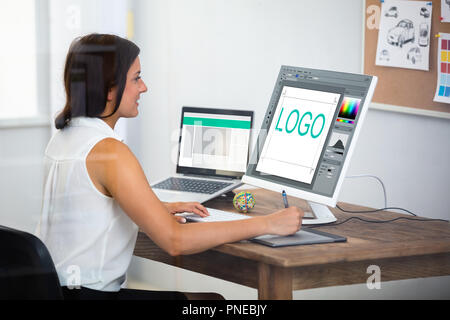 Female Designer Using Graphic Tablet While Working On Computer Stock Photo