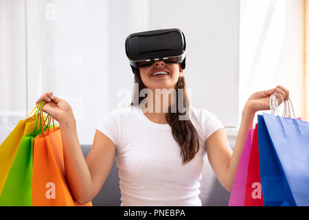 Happy Young Woman Holding Many Paper Bags Shopping With Virtual Reality Glasses Stock Photo