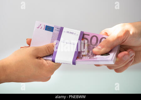 Close-up Of A Businessperson's Hand Taking Bribe From Partner Stock Photo