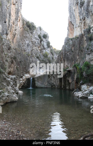 A rural landscape of a small lake and Aguavivas river waterfalls inside a rocky canyon dug by the warer, at the sunset, in the Aragon region, Spain Stock Photo