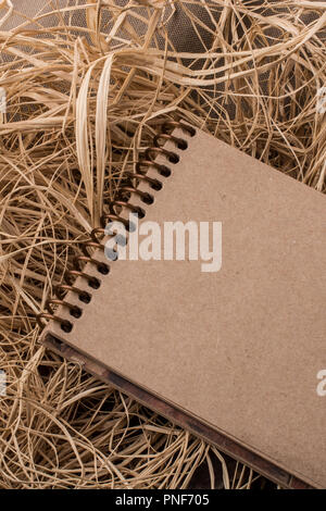 Spiral notebook placed on a straw background Stock Photo - Alamy