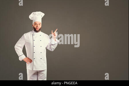 Funny cheerful chef in white uniform on background for text. Stock Photo