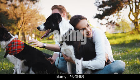 Beautiful couple walking dogs and bonding in nature Stock Photo