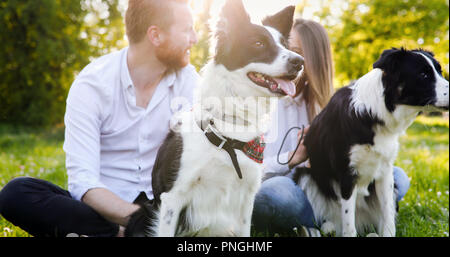 A young couple walking a dog in the park Stock Photo