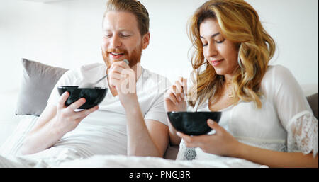 Young attractive couple having breakfast in bed Stock Photo